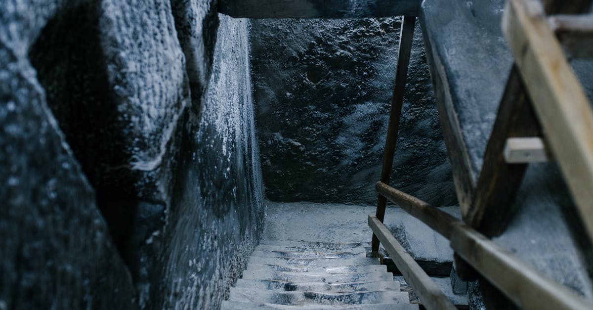 How to produce Ancient Fruits? - From above of aged stone stairway covered with salt in ancient cave with shabby walls and wooden railings in Registry Chamber of Salina Turda mine