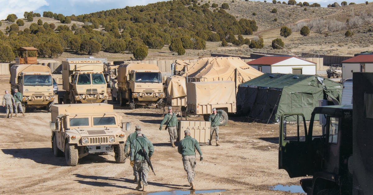 How to recover from losing soldiers - Man in Green Jacket Standing Beside White Van