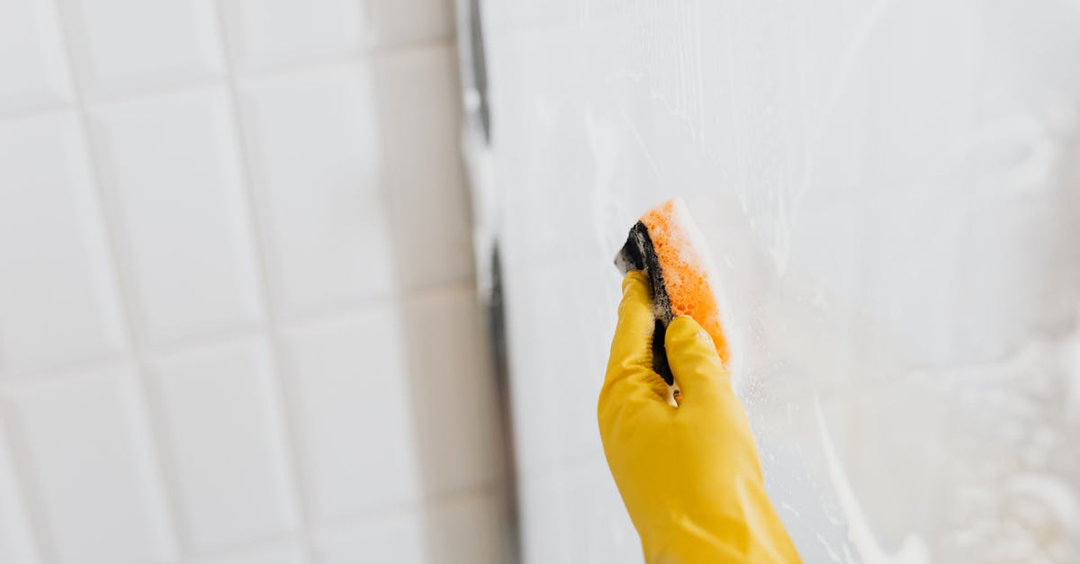 How to remove noble prisoners from dead factions? - From above of crop anonymous person in yellow rubber protective glove washing shower cabin glass with sponge and detergent