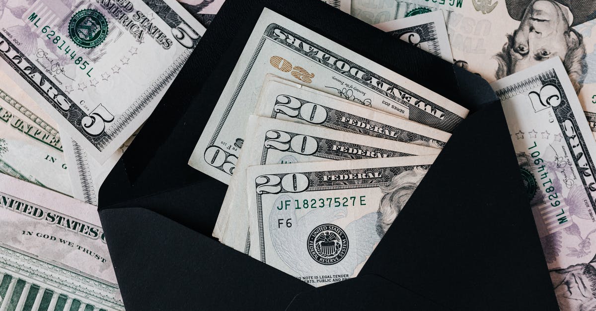 How to save a replay? - From above of dollar bills in opened black envelope placed on stack of United states cash money as concept of personal income