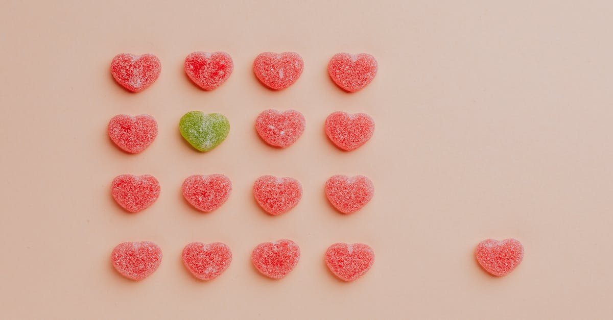 How to set a new baseline heart rate? - Top view of delicious sprinkled jelly sweets composed in lines with one candy aside on pink backdrop in candy shop