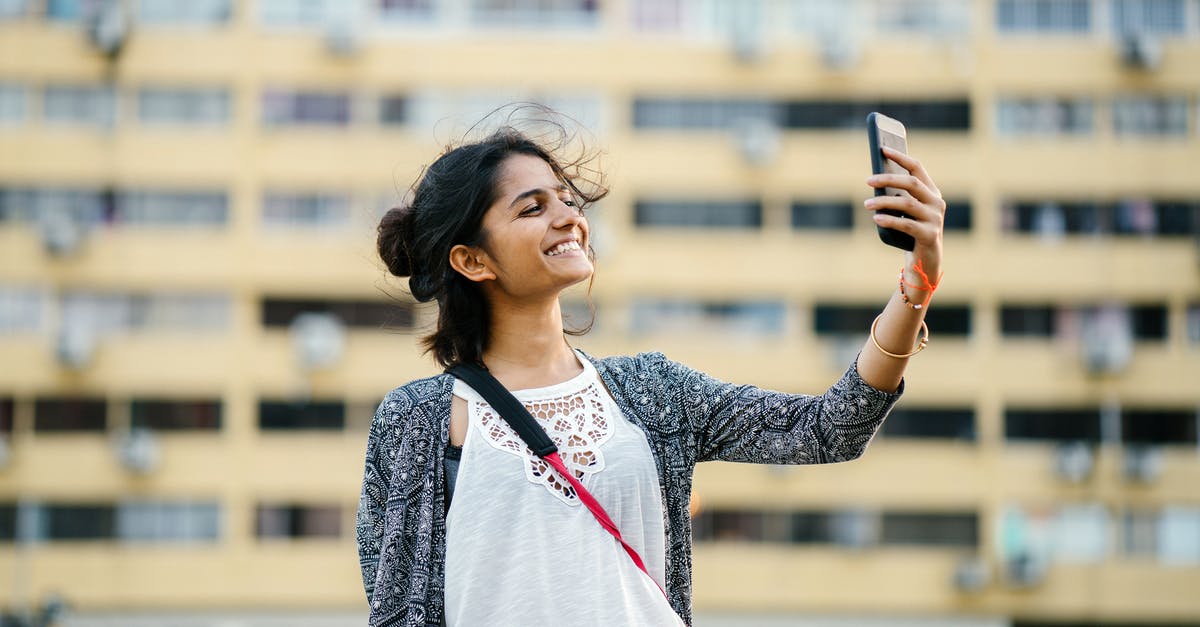 How to snap Frostina using the Yo-Kai Cam? - Smiling Woman Holding Black Smartphone