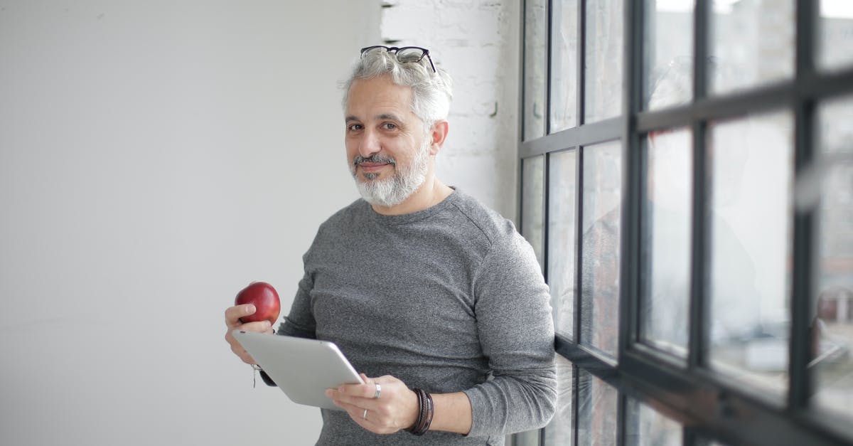 How to specify mana usage from my mana pool? - Smiling middle aged man using tablet and holding apple near window in office