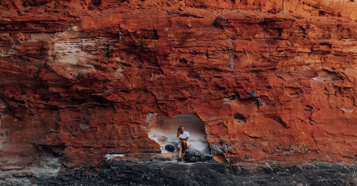 How to start the cave of dreams quest - Man in Gray Shirt Sitting on Brown Rock Formation