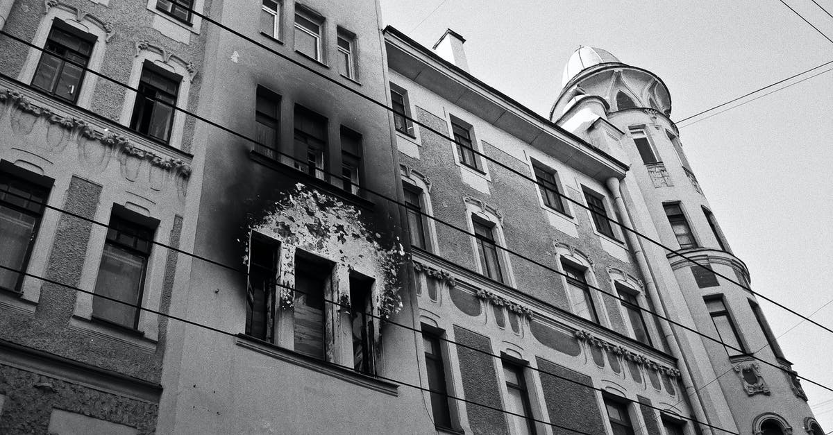 How to stop fire from going out without netherrack - Black and white of exterior of aged residential building with dirty windows and walls after fire placed in city in daytime