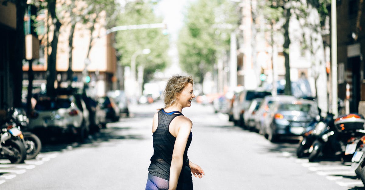 How to survive in the middle of a storm? - Woman in Black Tank Top and Blue Denim Jeans Sitting on Gray Concrete Road