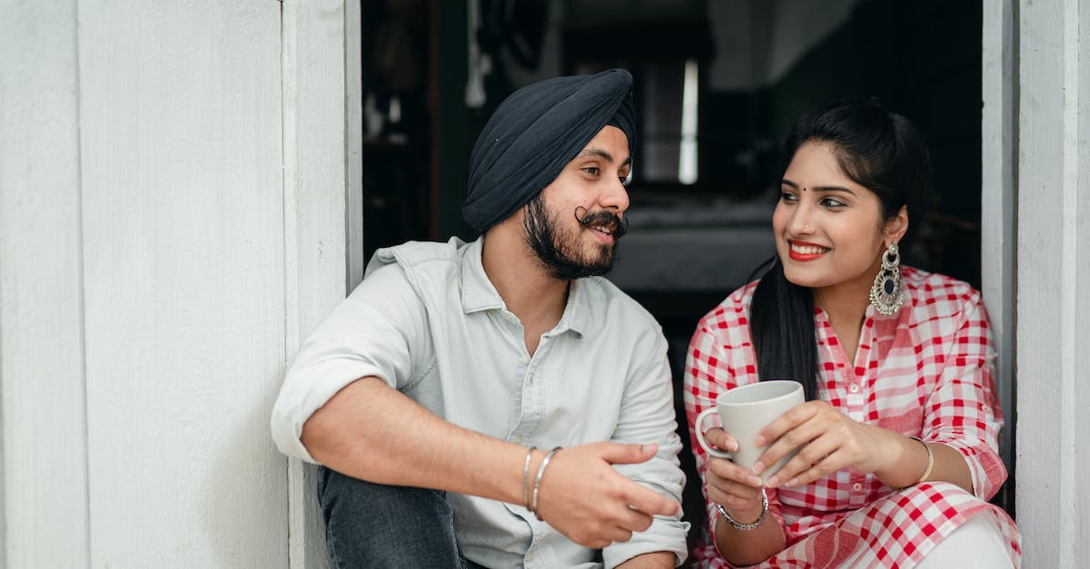 How to tell if I won a challenge? - Positive Indian spouses in casual outfits sharing interesting stories while drinking morning coffee on doorstep of house