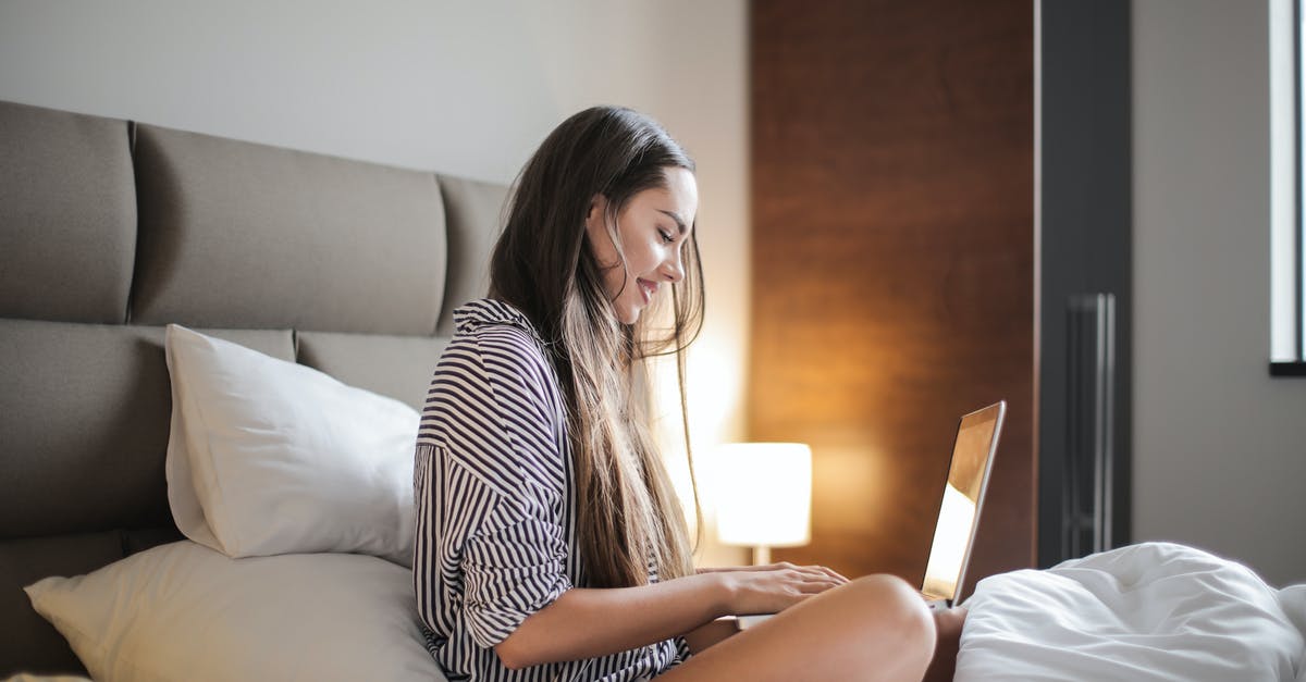 How to use multiple mics while streaming on twitch local - Side View Photo of Smiling Woman in a Black and White Striped Top Sitting on a Bed While Using a Laptop