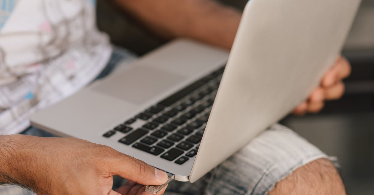 How were Memory Cards connected to the Original Xbox? - Crop faceless man using laptop and inserting flashcard