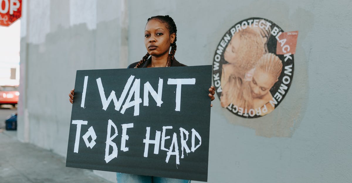 I lost to Mid-Boss. Do I want to proceed with NG+? - A Protester Holding Black Placard with Message