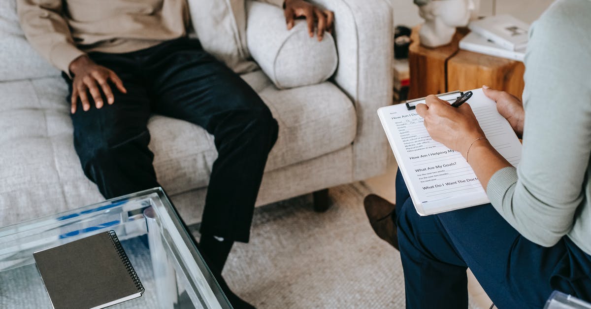 I need some help with this question - From above crop African American male in casual clothes sitting on comfy couch and answering professional female consultant questions in modern psychotherapy office