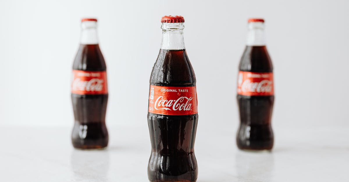 Identifying Uncraftables - Modern glass bottles of cold soda with red label placed on white reflective surface