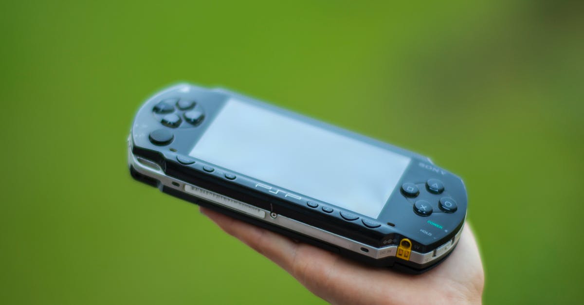 In what ways are the individual Persona games connected? - Closeup Photography of Person Holding  Black Sony Psp Handheld Console