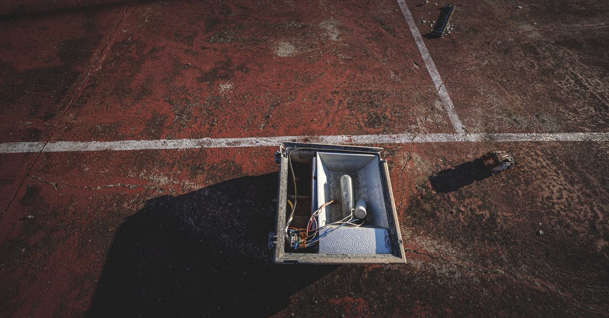 Installing Battlefield 3 from a Bluray disc without the game box - From above of outdoor lamp box placed on rough dirty ground of sports court on sunny day