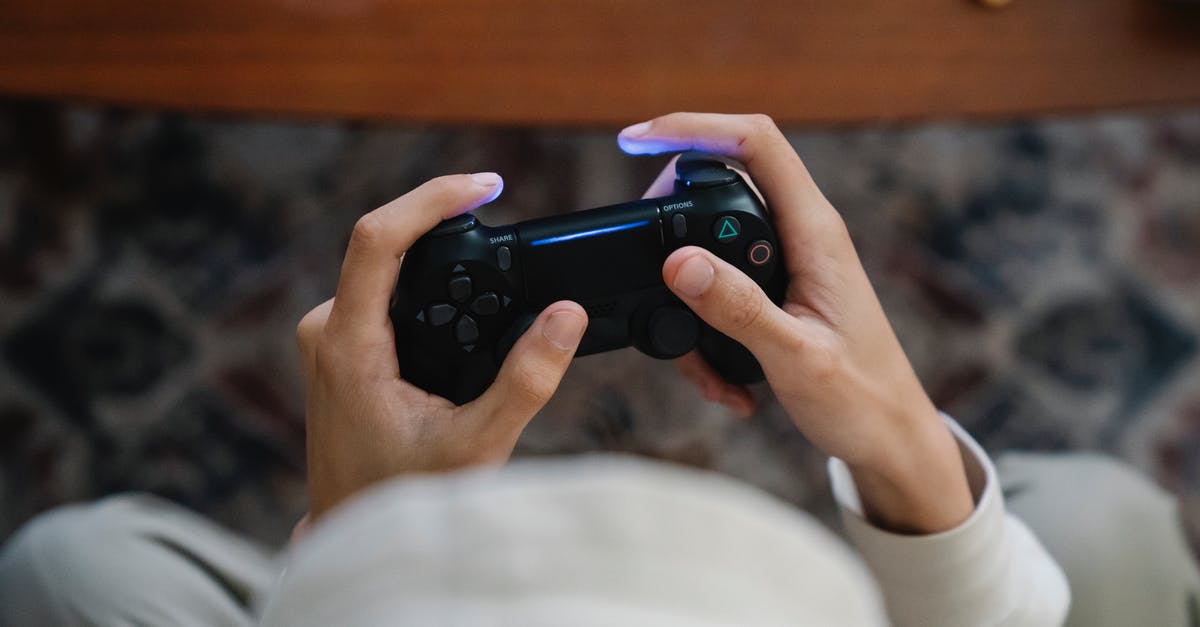 Invert gamepad button to avoid RSI - From above of crop unrecognizable male with console controller playing video game in living room