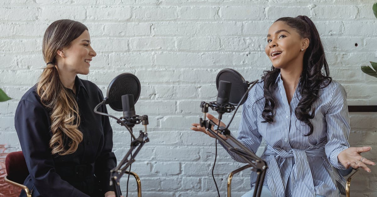 Is it possible to host Magicka in a LAN without steam? - Smiling African American female guest gesticulating while having interview with journalist sitting near mic