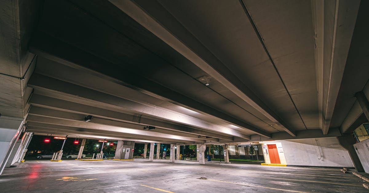 Is it possible to place an outgoing underground belt first? - Entrance to underground parking with empty spaces under concrete roof at night time