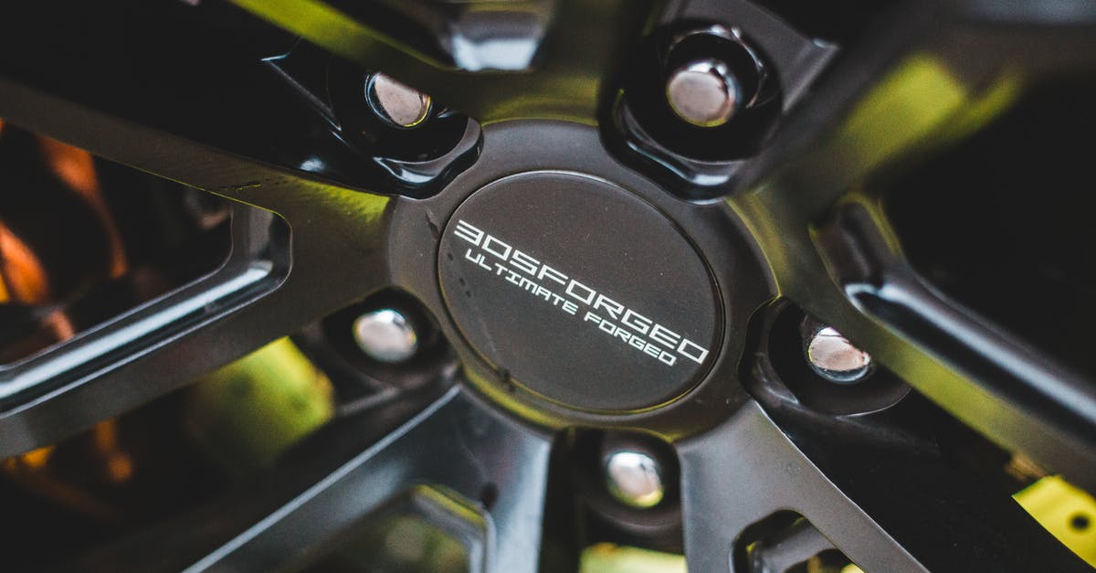 Is it possible to rotate an object? - Closeup of new alloy wheel with silver screws in front of brake disc of sport automobile