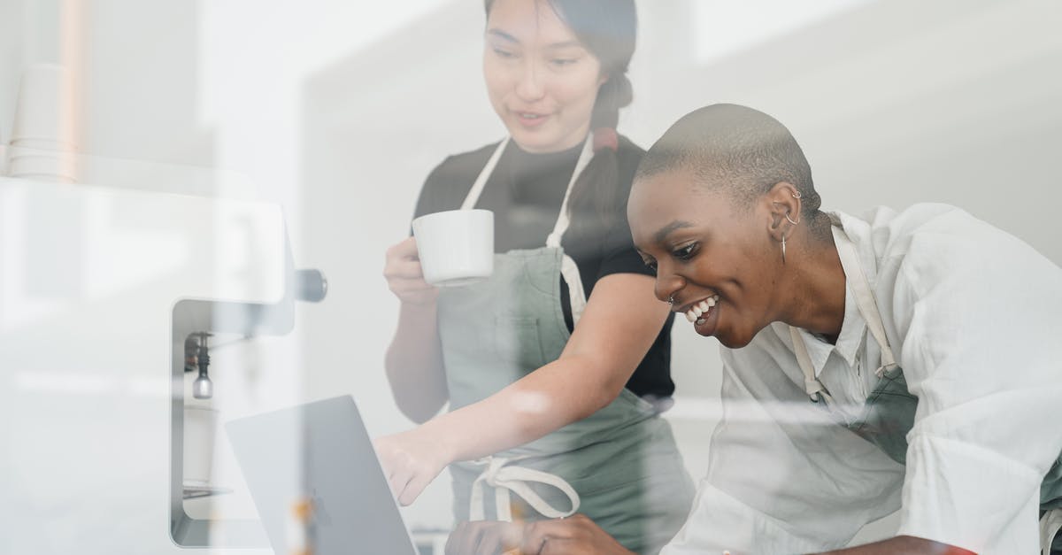 Is it possible to unlock new guns without using Multiplayer? - Through glass of friendly young Asian head barista showing young cheerful African American female coworker how to use special program on laptop