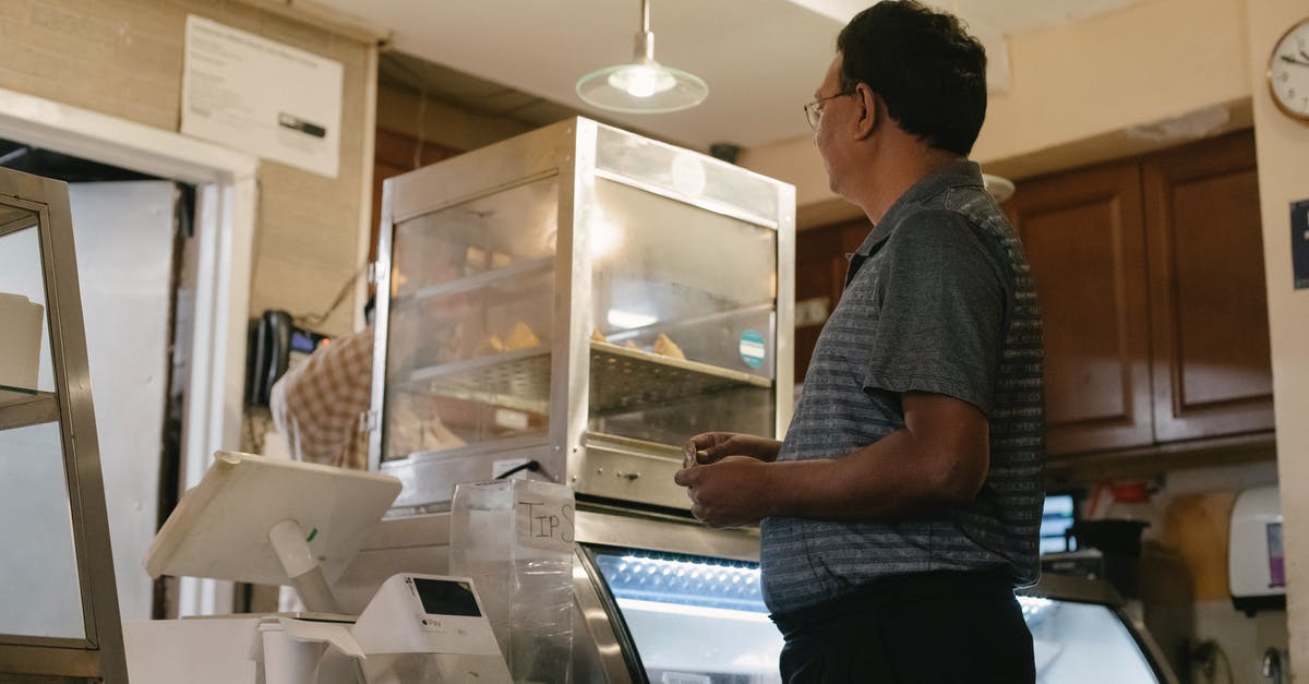 Is there a good counter to wedge + biggs combo? - Side view of ethnic male wearing casual clothes standing near showcase and cash register while buying food in grocery store