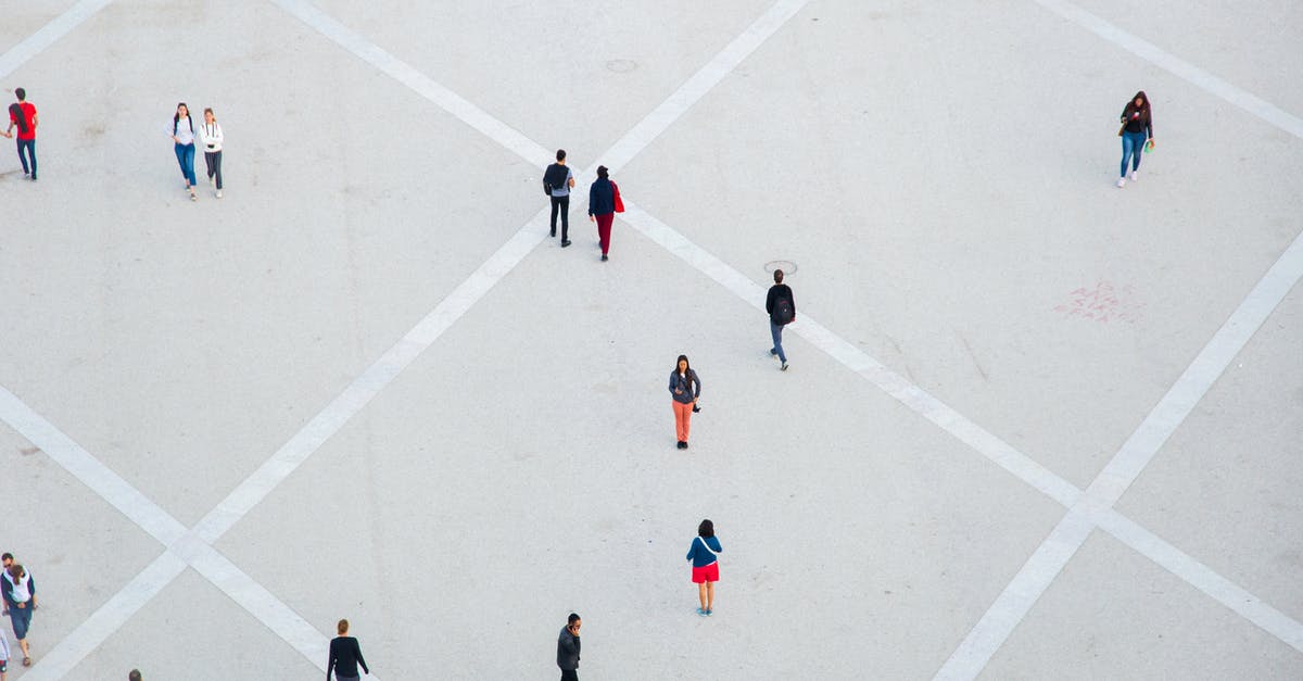 Is there a path which continues from here? - High angle citizens in casual wear walking on vast concrete ground in city square