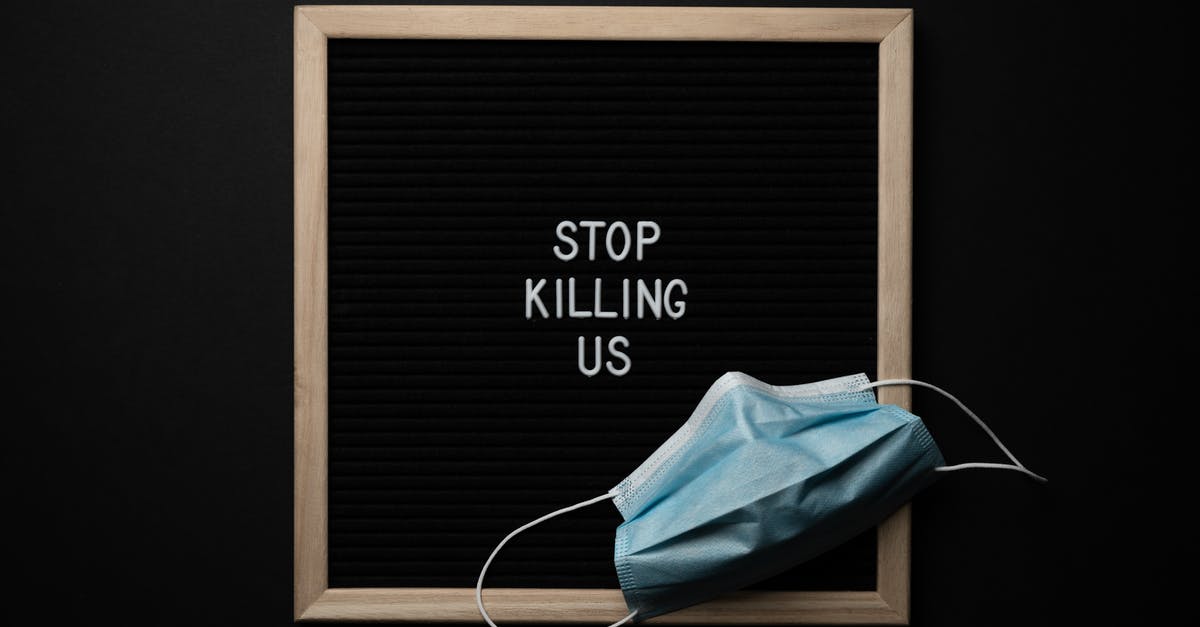 Is there a penalty for escaping from fights? - Top view of composition of blackboard with written phrase STOP KILLING US under mask against black background