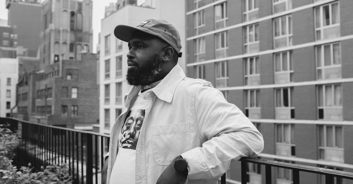 Is there a population cap for cities in SC4? - Black and White Portrait of a Man in a Cap Leaning on a Balcony Railing