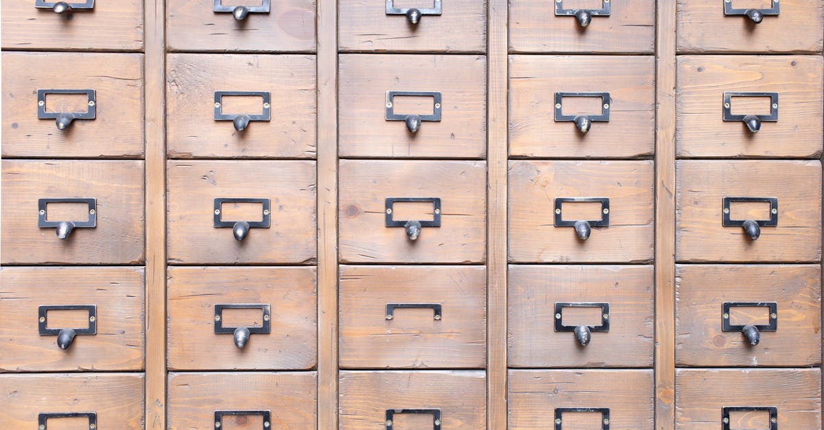 Is there a reason to keep duplicate mastered pins? - Background of wall full of many similar aged shabby vintage wooden drawers with metal round handles