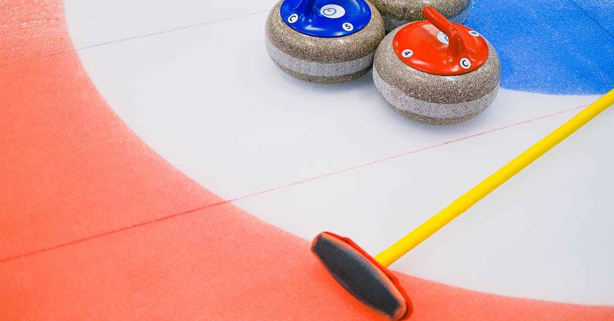 Is there a share code for this Aim Arena/Sniper's Alley custom game? - From above of heavy multicolored granite curling stones and long brush placed on ice with circular target area in arena