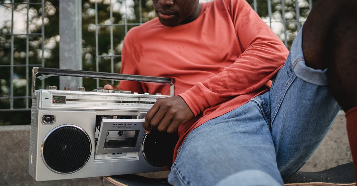 Is there a way to change displayed buttons? - Crop black man in casual clothes opening retro recorder to change cassette during resting on concrete surface with skateboard in city street