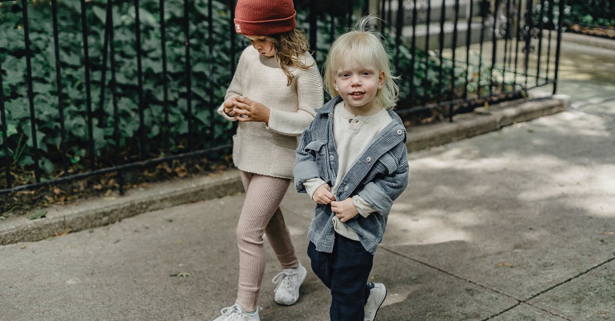 Is there a way to not change camera angles? - Cheerful siblings walking on sidewalk