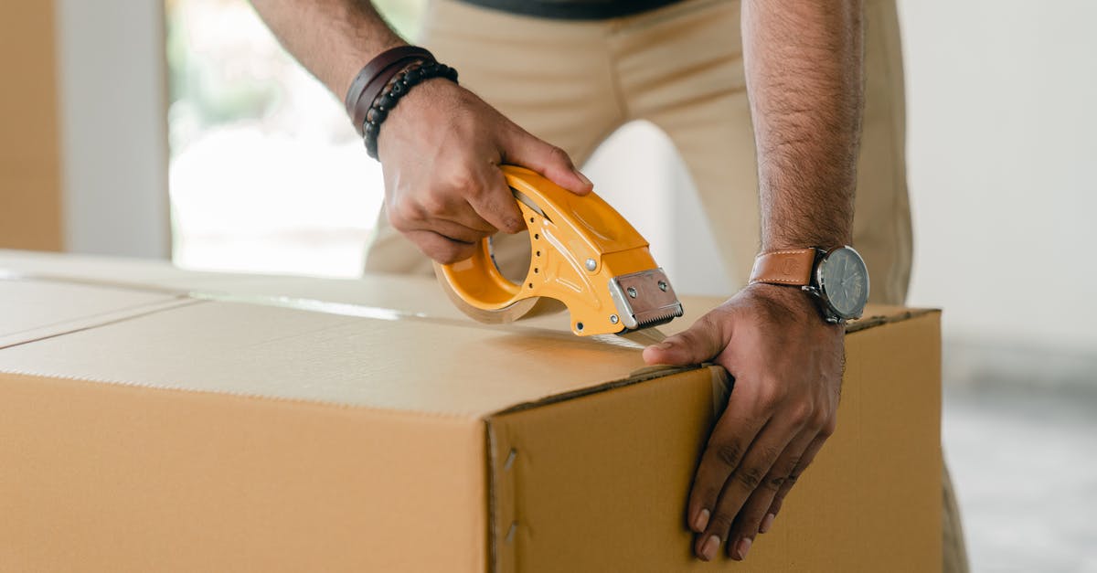 Is there a way to revert tool order customizations? - Crop faceless young male with wristwatch using adhesive tape while preparing cardboard box for transportation