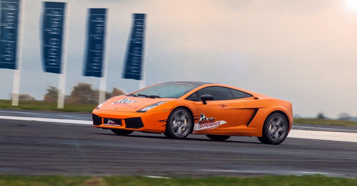 Is there a way to rotate myself? - Modern luxury orange sports car riding fast on asphalt highway at race at daytime under bright sky