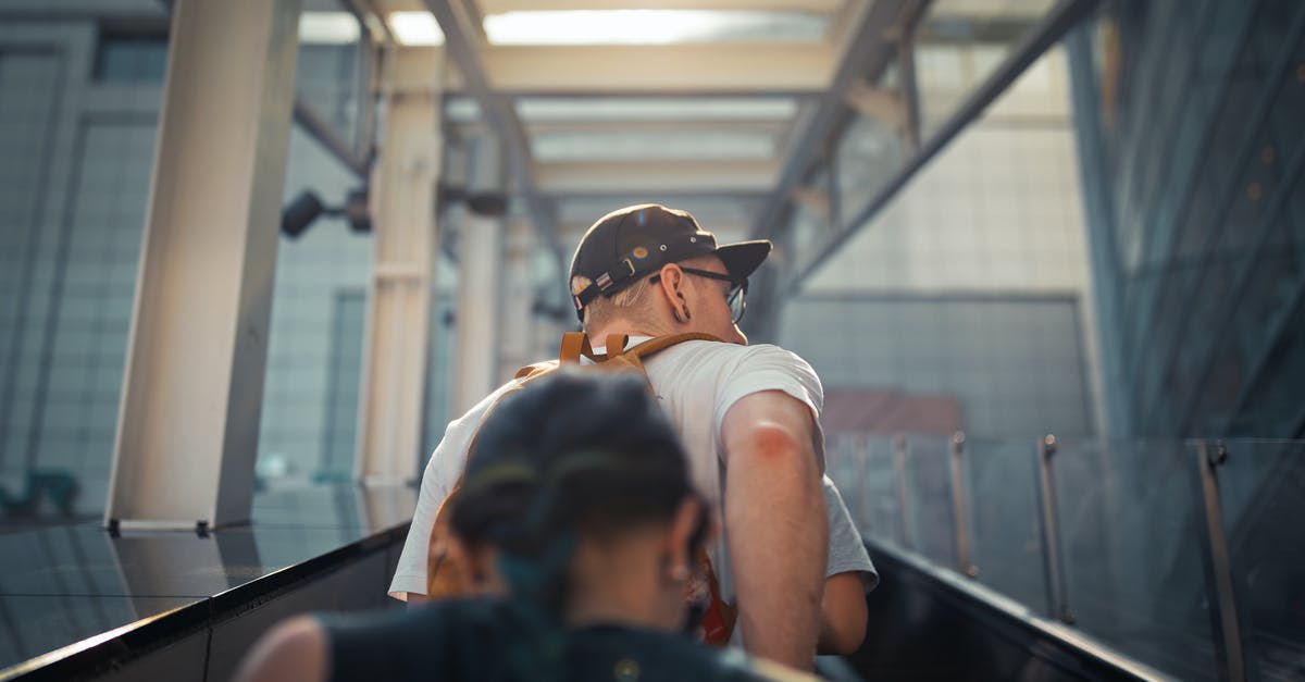 Is there an optimum way to level up characters? - From below back view unrecognizable people in casual wear going up on outside escalator of modern building in daylight