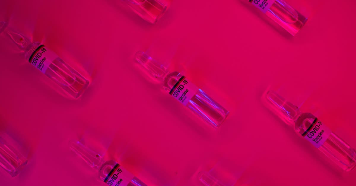 Is there any way to reduce repeated science experiments? - Layout of doses of coronavirus vaccine in glass transparent vials placed on bright fuchsia background in studio