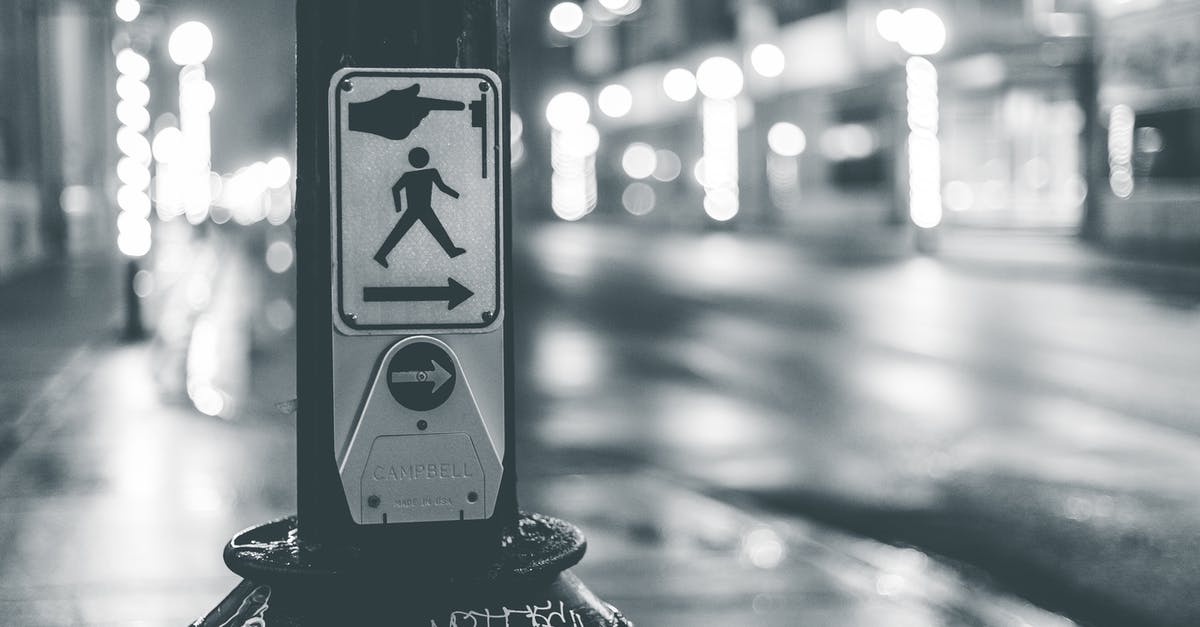 Is there any way to stop this character's death? - Pedestrian crosswalk button placed near roadway in city in evening time