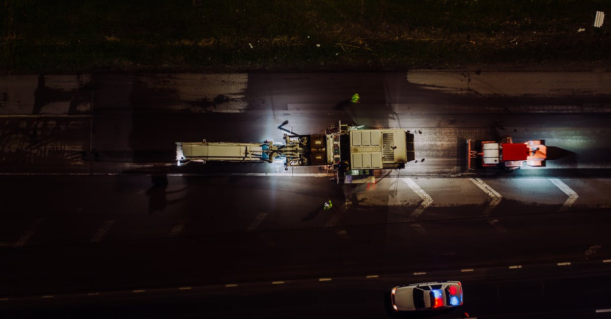 Is there way to fix save files? - Top view of specialized vehicles with lights on repairing road and laying asphalt and concrete at night