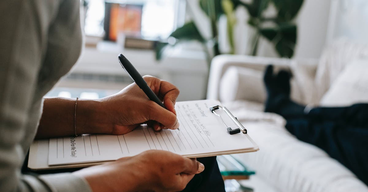 Jetpack Joyride issue - Unrecognizable ethnic female therapist taking notes on clipboard while filling out form during psychological appointment with anonymous client lying on blurred background