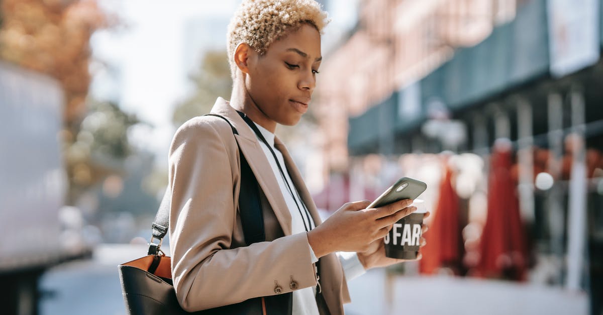 Killer instinct cross plataform online? - Side view of concentrated young African American female text messaging on smartphone while crossing road and drinking coffee