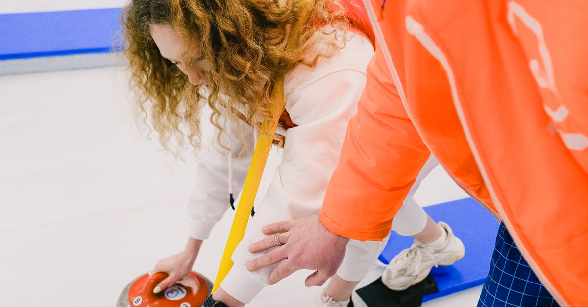 LoL player needs help configuring DotA 2 quick cast controls - Man instructor fixing position of hand of female curling player