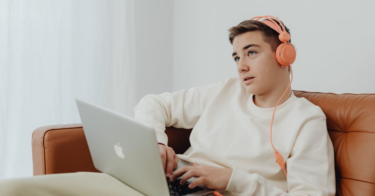 Minecraft icon is disappearing on Mac taskbar - Teenage Boy Using a Laptop and Headphones