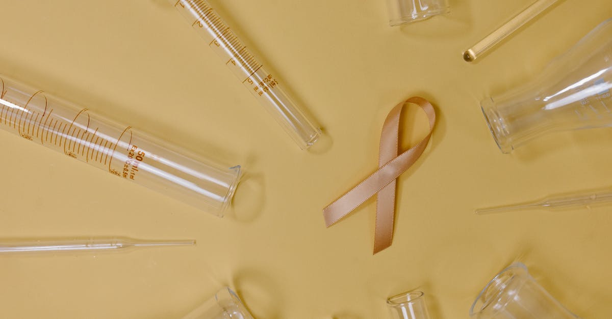 Minecraft Sign Command give tool help [1.8] [duplicate] - Top view of pink ribbon representing cancer placed on yellow background among glass test tubes and flasks in light studio