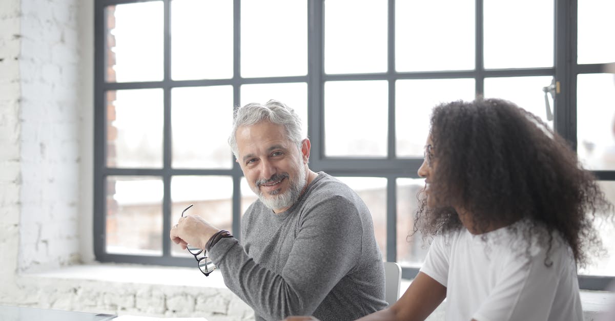 Minecraft Wither Boss help - Happy aged gray haired coach in casual wear looking at camera while supporting young African American coworker in office boardroom