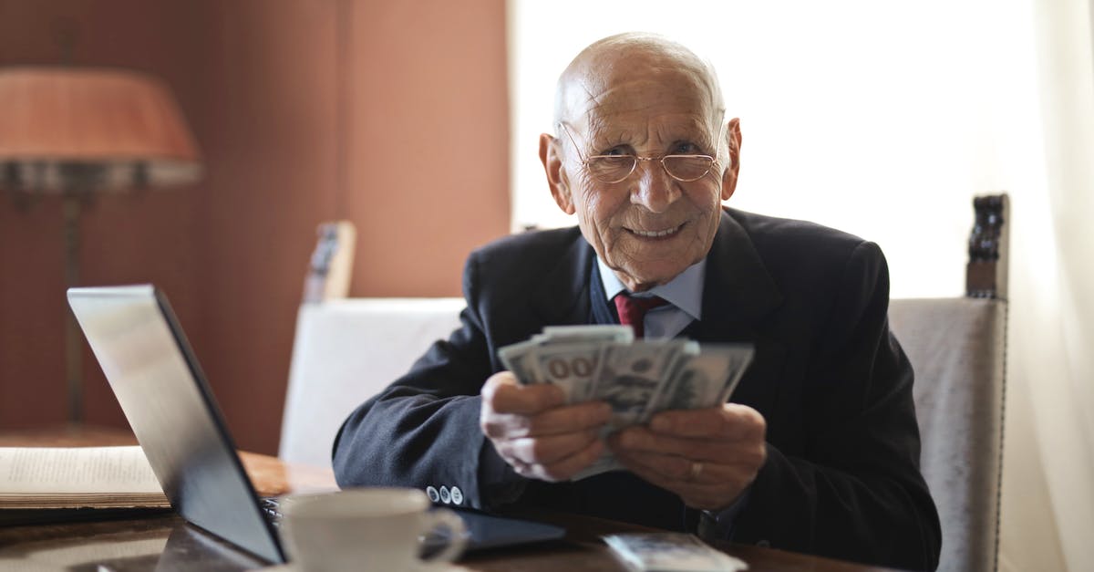 Modding the Sentry spawn for Payday 2 - Confident senior businessman holding money in hands while sitting at table near laptop