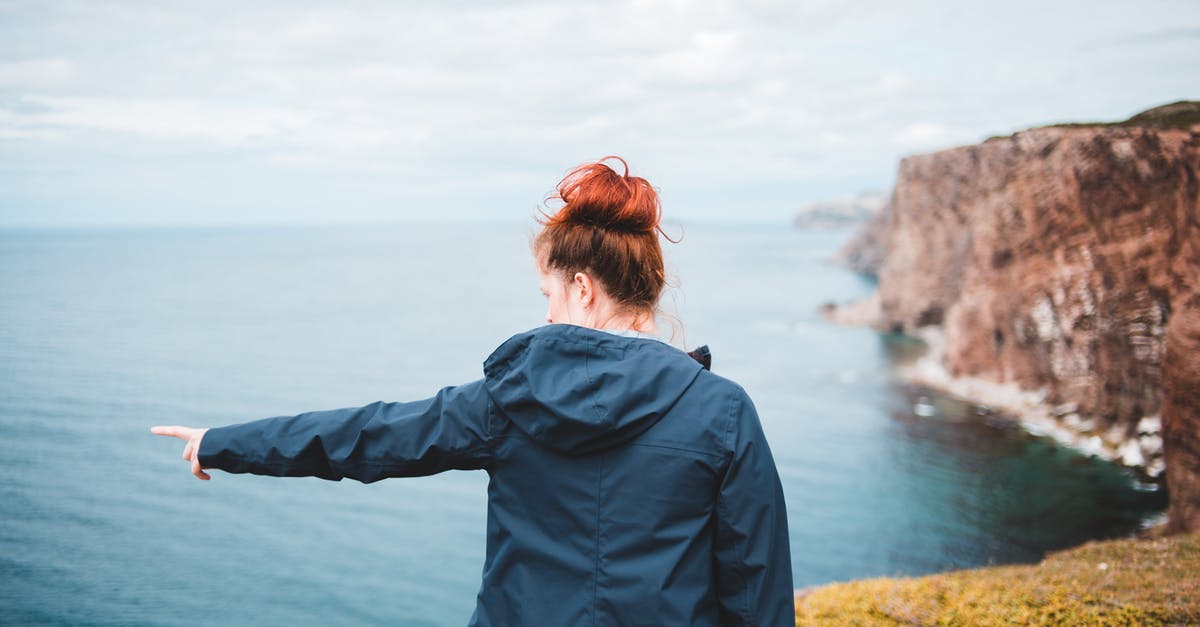 Mount and Blade Viking Conquest: I'm stuck in a point of the main questline (SPOILERS) - Back view of unrecognizable female traveler with red hair showing ocean with finger while standing on mount under cloudy sky