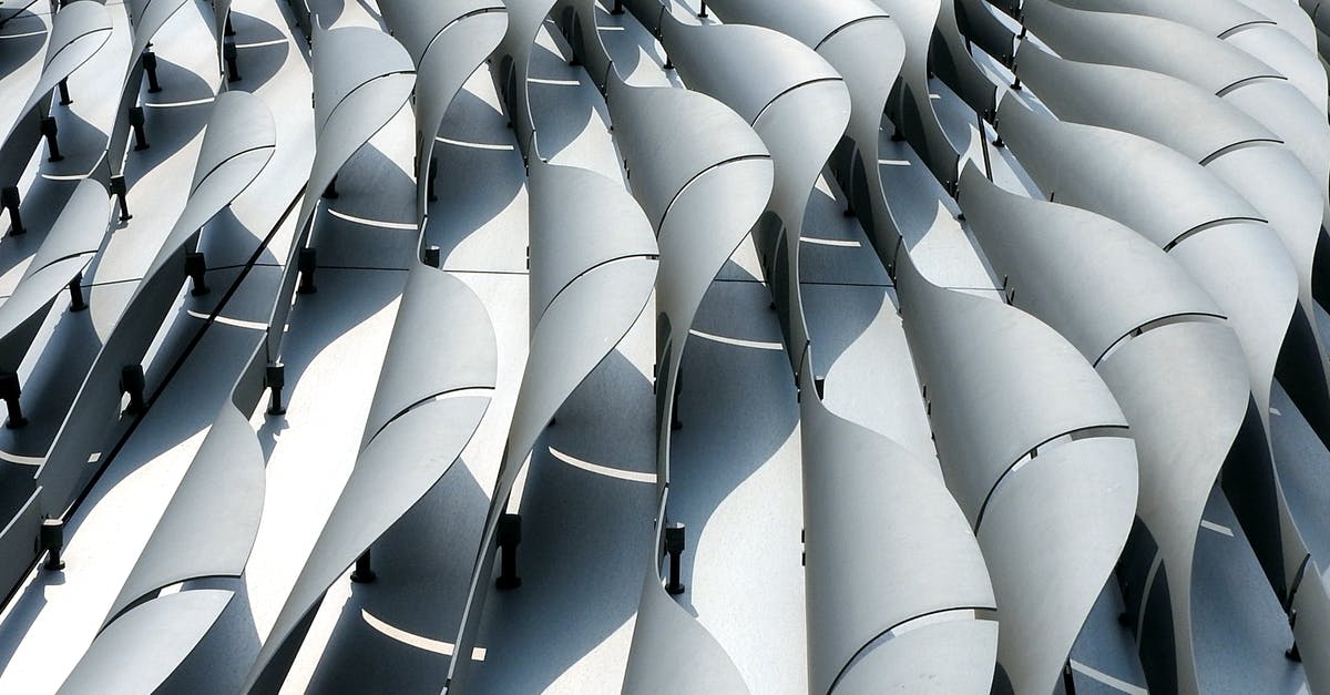 New liset segment - Curved ribs of gray color on wall of futuristic building shining in daylight