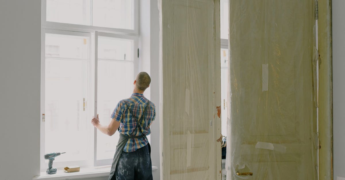 New Oculus Rift S installed on Windows 10 and now machine keeps crashing - Back view of unrecognizable workman in apron mounting window near drilling machine and doors in flat