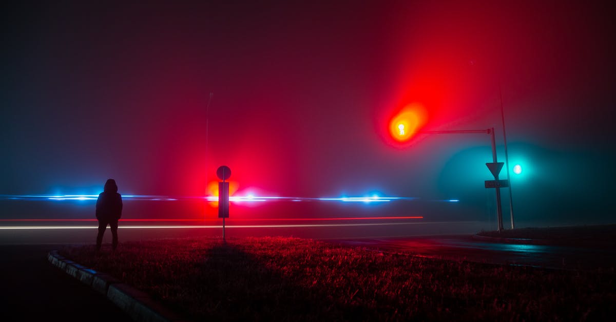 No UFO sightings and landings? - Unrecognizable Person Observing Red and Blue Lights on Road at Night