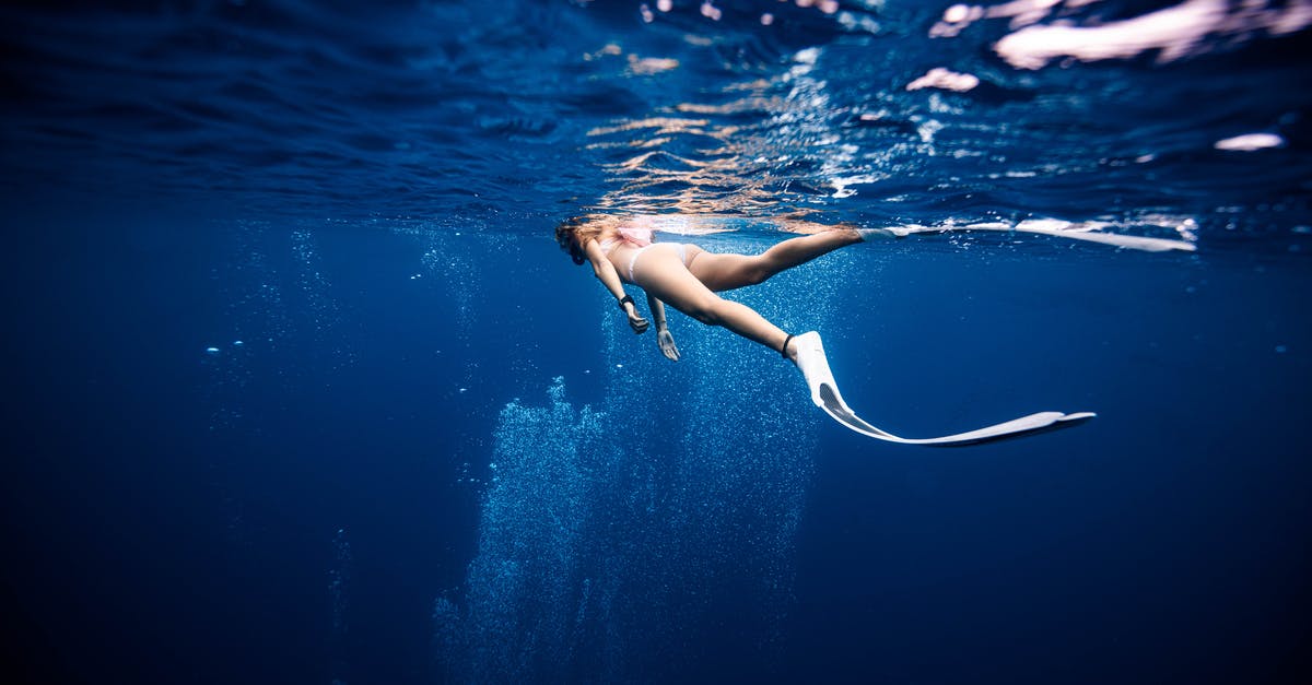 Number of scanned surfaces in deep space - Female diver in swimwear and flippers swimming on surface of deep blue ocean