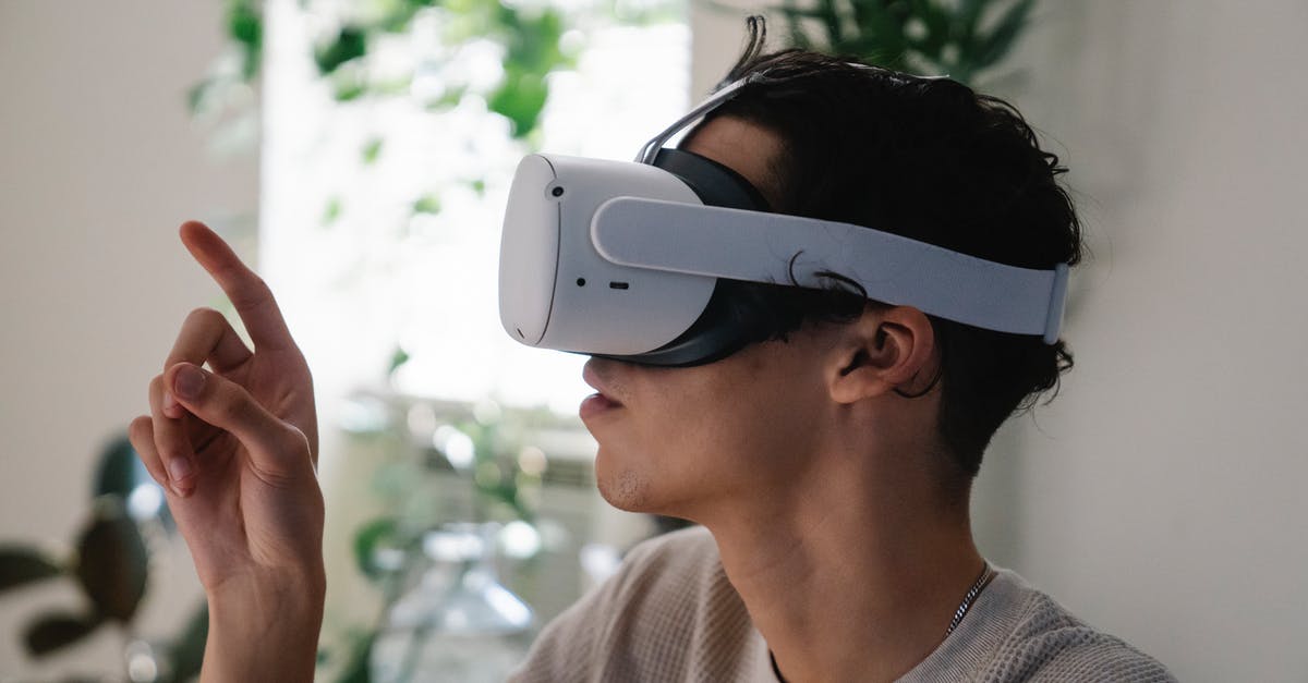 Oculus rift cv1 - some games are not displaying video in the headset - Side view of concentrated young guy in casual clothes experiencing virtual reality in modern headset at home